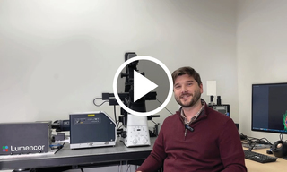 Andrii Repula, discusses latest White Paper "Laser Light Engine Output Stability" sitting in lab with microscope connected to CELESTA Light Engine.